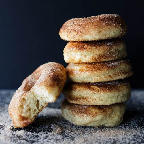 Zelfgemaakte appeltaart doughnuts, gebakken en bestrooid met kaneelsuiker, perfect voor een herfstige snack of zoet recept.