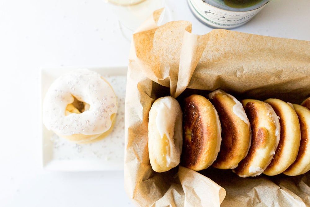 Luchtige gebakken champagne donuts, verrijkt met champagne in zowel het deeg als de glazuur, ideaal voor een feestelijke nieuwjaarsviering.