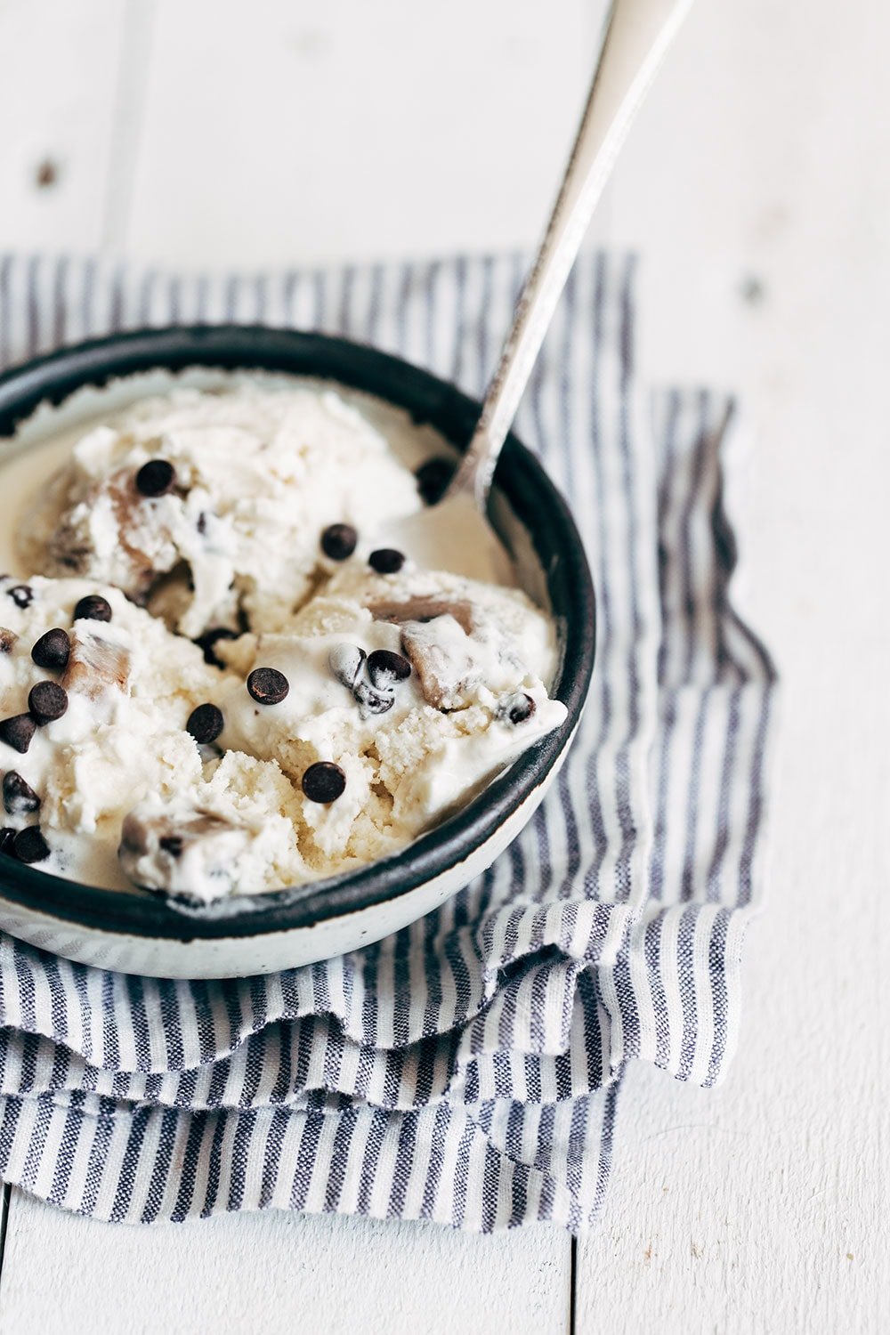 Een schaal zelfgemaakt chocolade chip cookie dough ijs met een lepel erin, romig en vol koekjesdeeg, ideaal voor dessert- en ijsspecialiteitenfotografie.