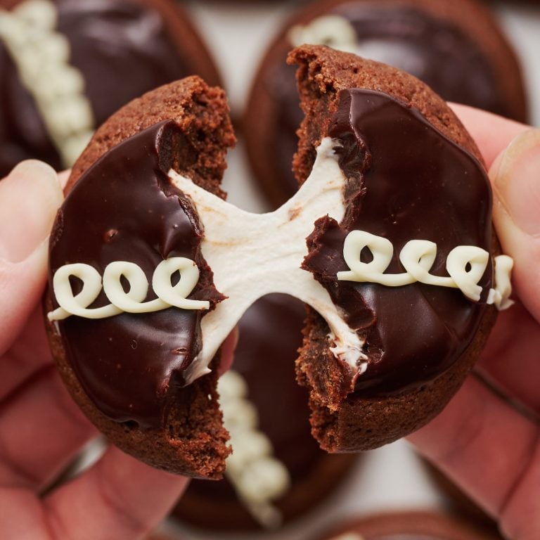 Hostess cupcake cookie doormidden gebroken en uit elkaar getrokken, met smeltende marshmallow die tussen de twee koekjeshelften trekt.