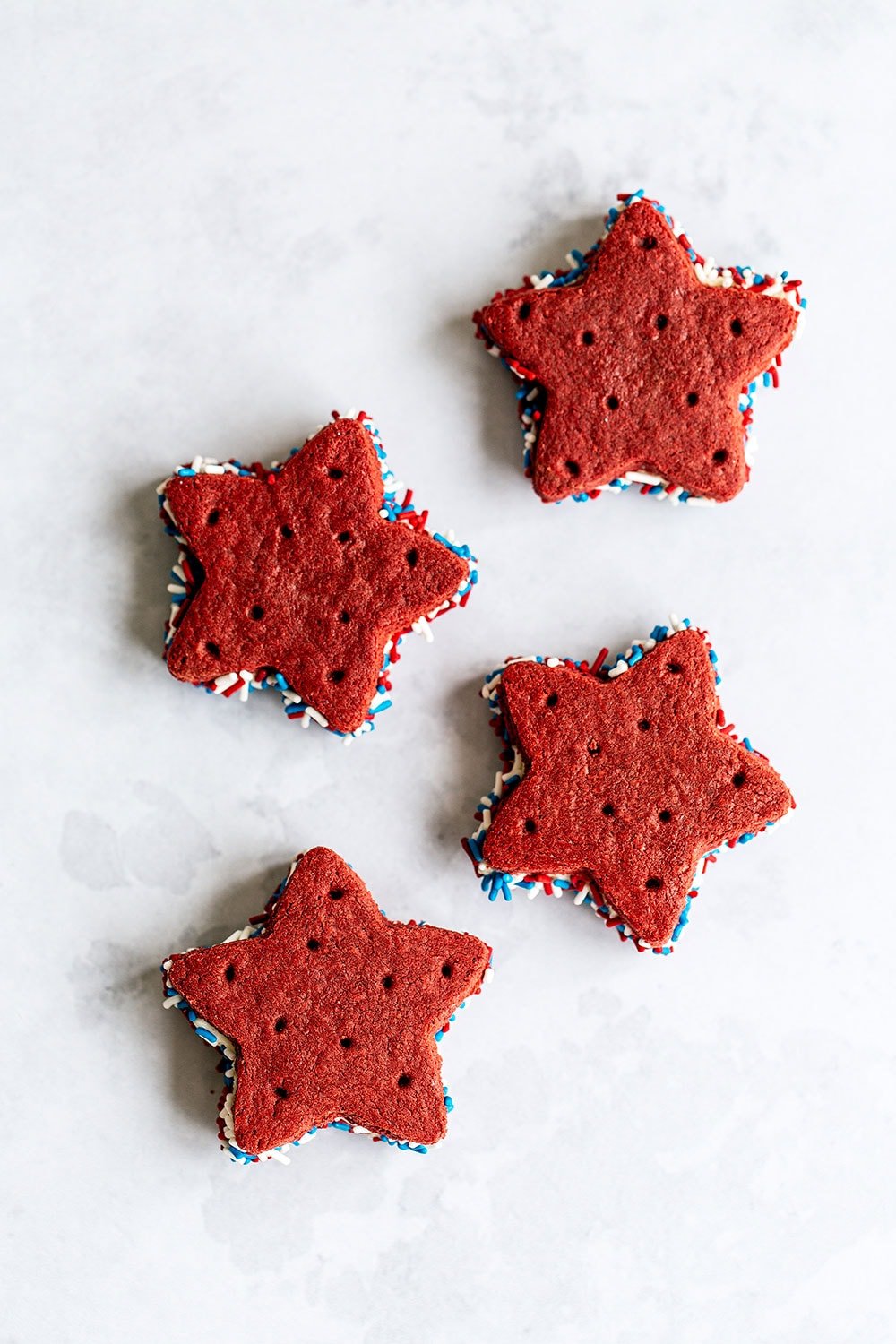 Easy red velvet ice cream sandwiches with homemade cookies, served on a marble surface, perfect for dessert and ice cream photography.