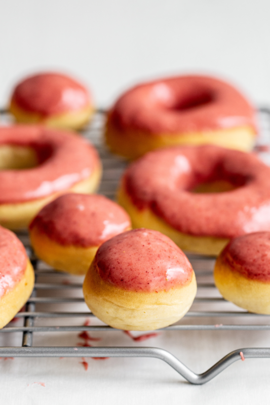 Strawberry lemon donuts and donut holes on a wire rack, perfectly glazed and ready to serve, ideal for dessert and bakery photography.