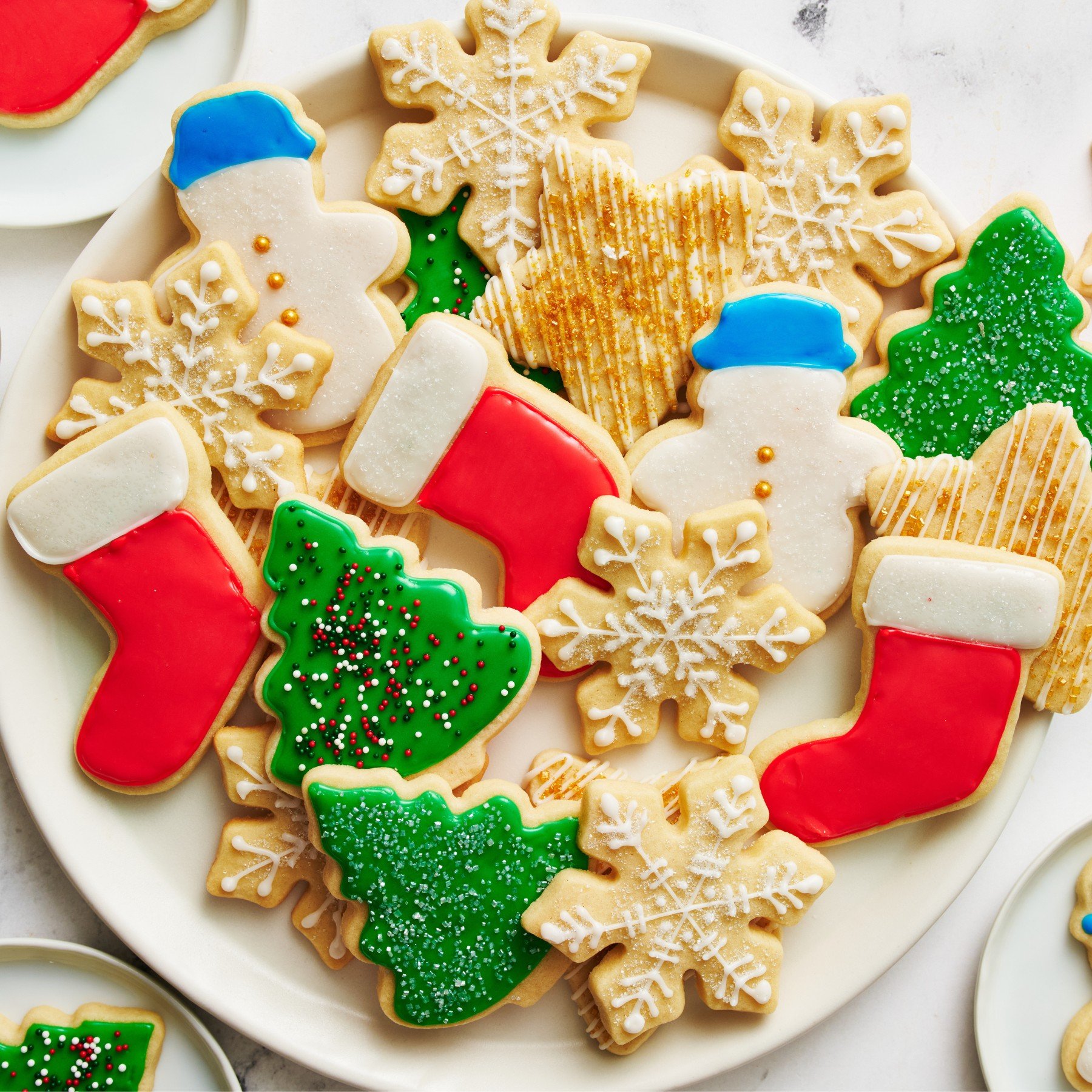 Een bord met iced en versierde suiker koekjes.