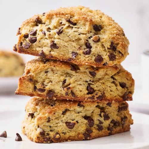 Stapel van drie zelfgemaakte chocolate chip scones met gesmolten chocolade en een gouden korst