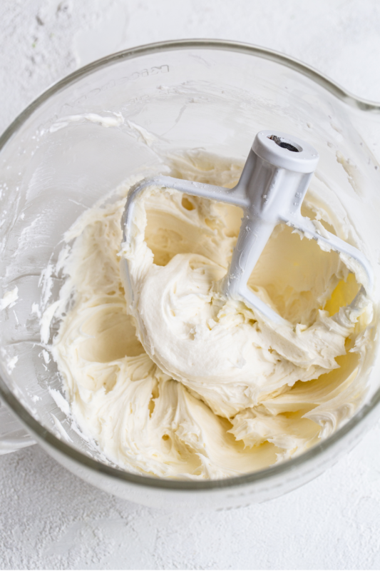 Botercrème in een glazen kom, luchtig opgeklopt en klaar voor het decoreren van taarten of cupcakes.