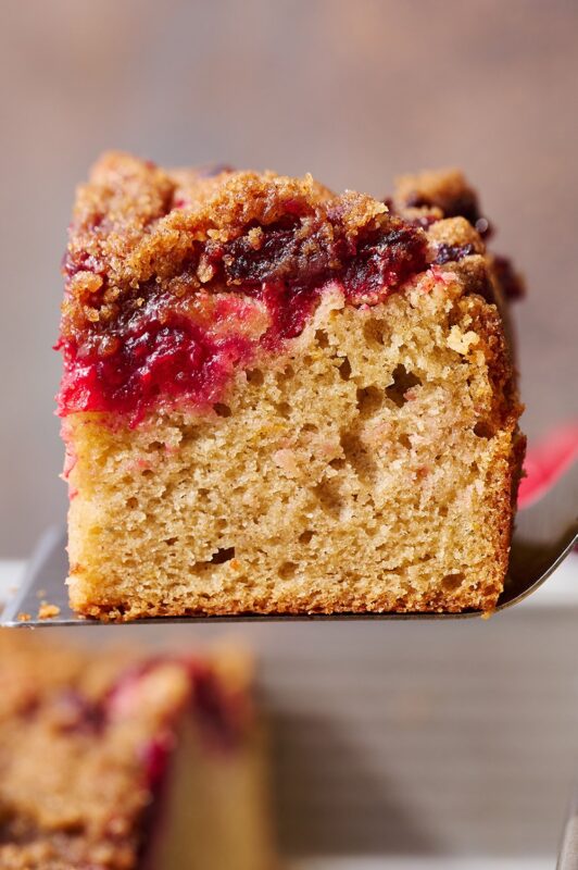 Een smakelijke plak cranberry-sinaasappel koffie cake, perfect geserveerd voor elke gelegenheid.