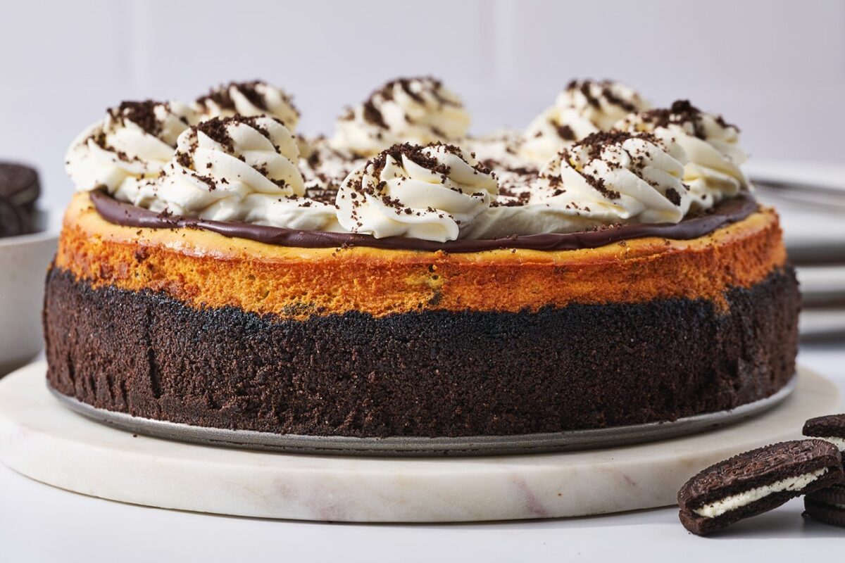 Huisgemaakte Oreo cheesecake met een romige vulling, bedekt met Oreo koekjes en een krokante bodem van verkruimelde koekjes.