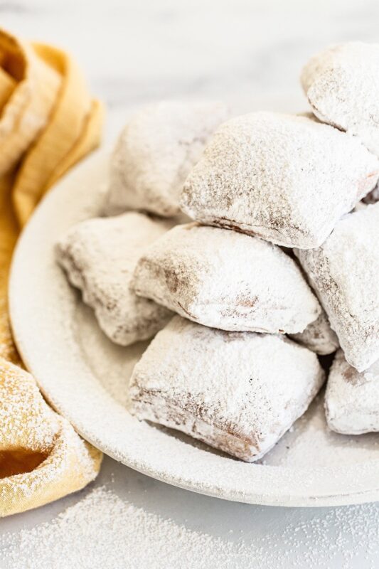 Versgebakken, goudbruine beignets op een bord, klaar om van te genieten.