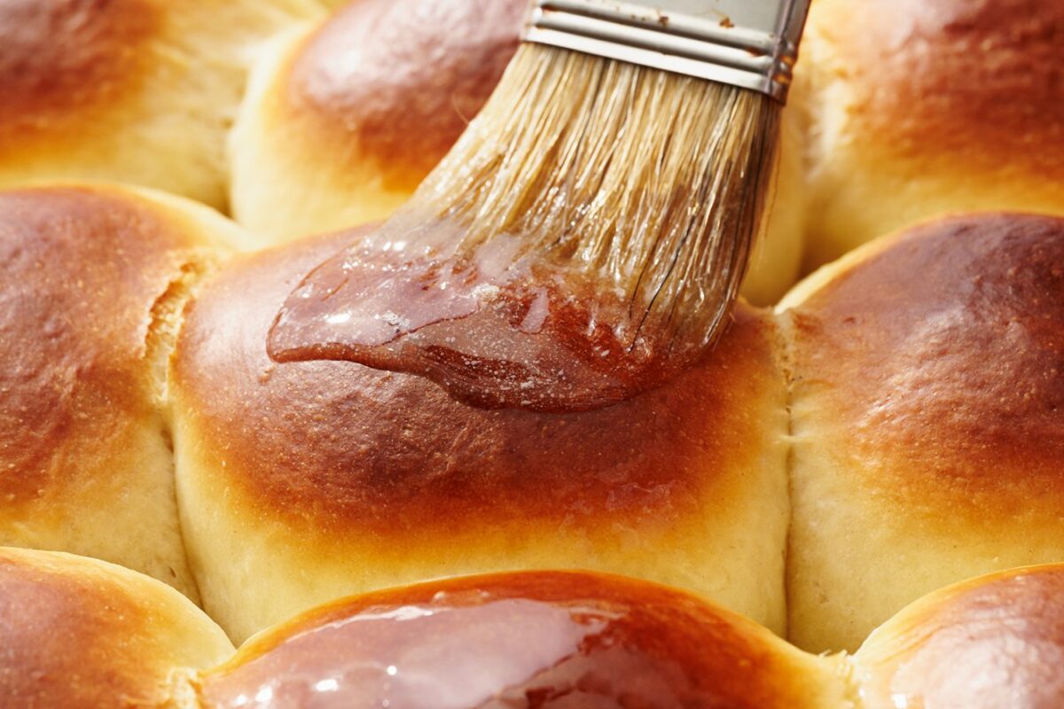 Hawaiiaanse rollen vers uit de oven, ingesmeerd met gesmolten boter, met een gouden korst