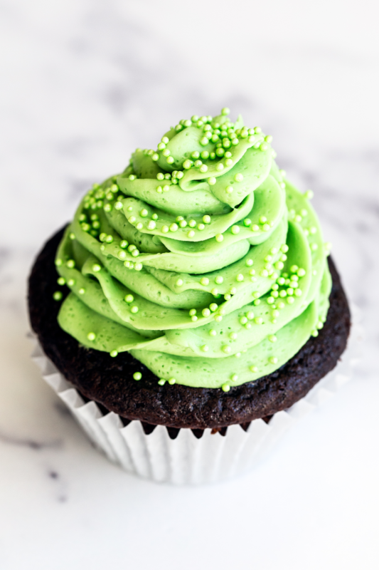 Mint chocolade cupcake, prachtig gegarneerd met munt frosting en groene sprinkles voor een verfrissende uitstraling.