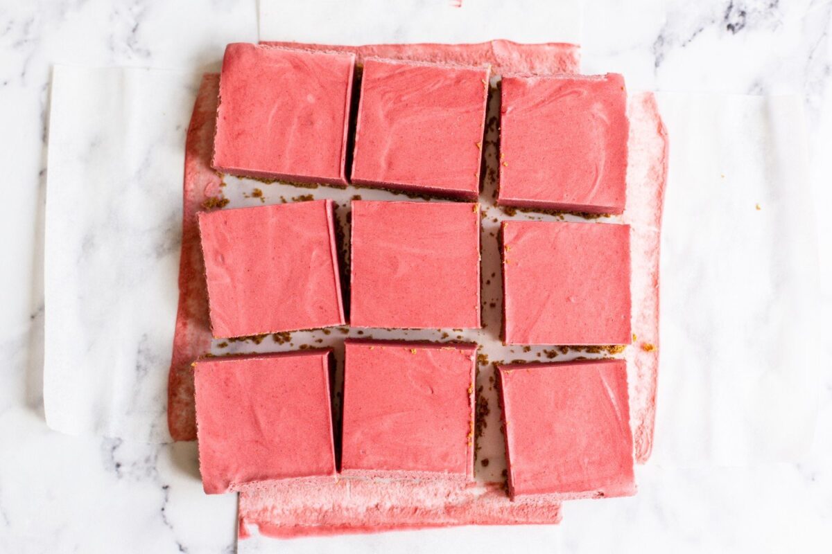 Een pan met aardbeien cheesecake bars, in 9 stukken gesneden, ideaal voor dessert- en bakkerijfotografie.