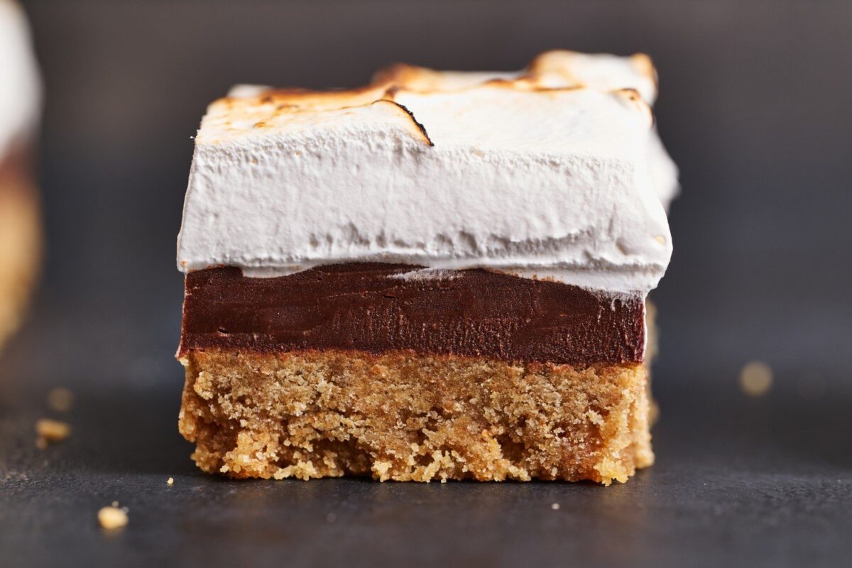 Een enkele s'more bar op een witte achtergrond, met een duidelijk zichtbare laagjesstructuur van chocolade, marshmallow en grahamcracker.