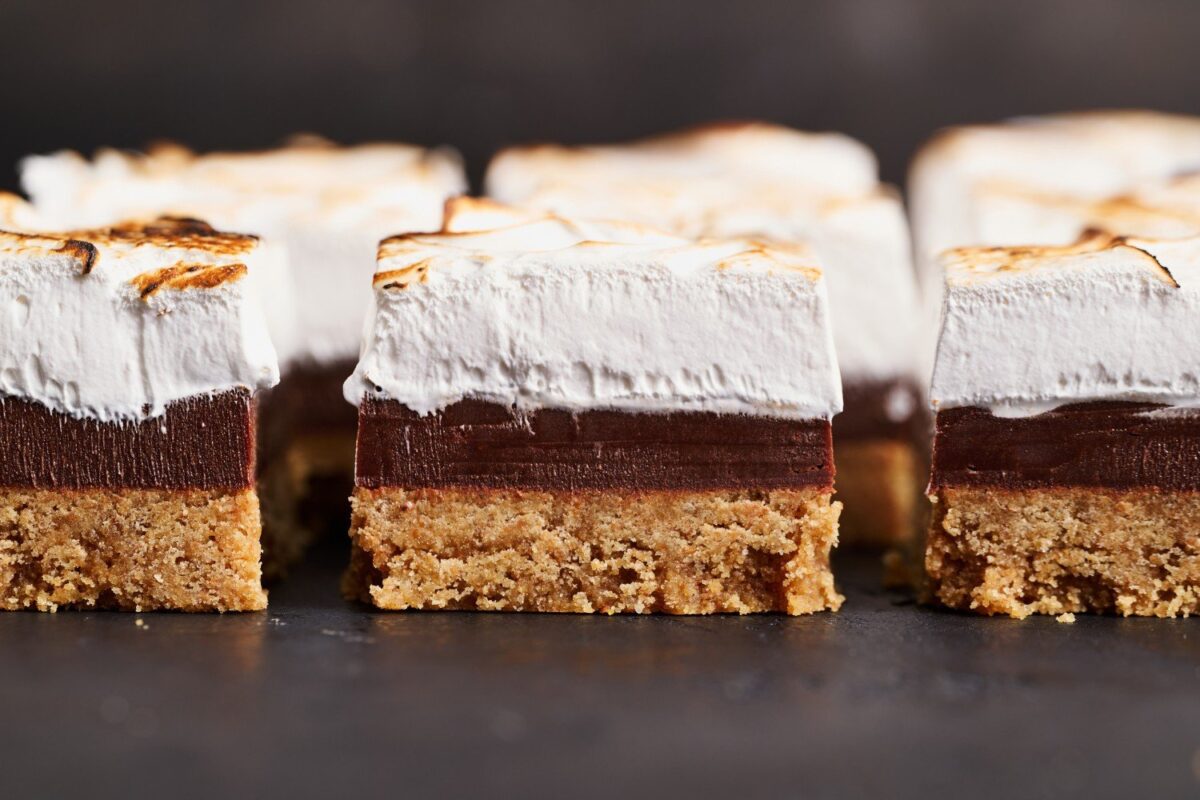 Een rij heerlijke gesneden s'mores fudge bars, perfect gepresenteerd tegen een donkere achtergrond.