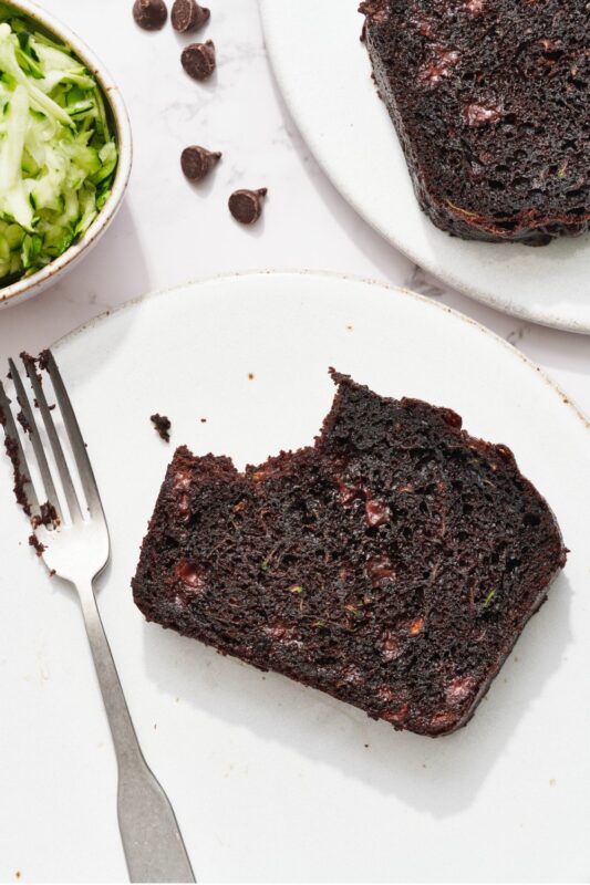 Een plak quickbread op een bord met een vork, met een hap eruit, perfect voor een smakelijke traktatie.