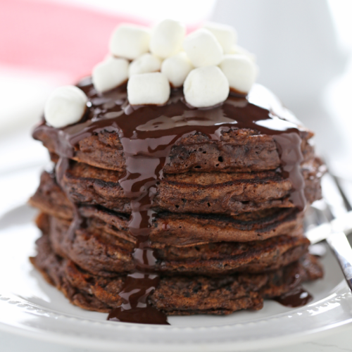 Een stapel Hot Chocolate Pancakes met mini marshmallows bovenop.