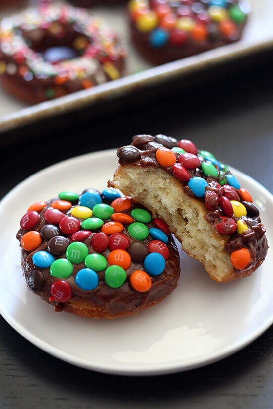 M&M Cake Doughnuts zijn gefrituurde perfectie, bedekt met een dikke chocoladeglazuur en knapperige m&m's en zijn veel sneller te maken dan gistdonuts!